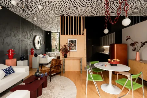 Nowoczesny salon w loftowym apartamencie Mateusza Banasiuka z ciemnymi ścianami i autorskim wzorem na suficie