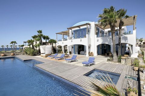 Jak w domach na Capri: biała elewacja i błękitne obramowania okien i drzwi.