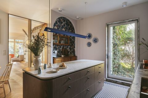 otwarta kuchnia z wyspą i designerską podłużną lampą nad blatem