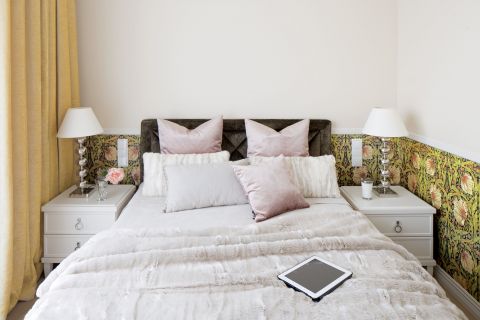 Na ścianie tapeta zaprojektowana przez Williama Morrisa. Różowe poduszki – BoConcept, pozostałe i futerkowy pled – BBHome.