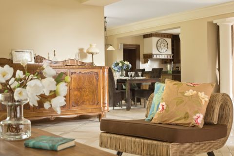 Beże i brązy, solidne dębowe meble i obraz z zabytkowym sportowym samochodem. Klasyka w najlepszym stylu.