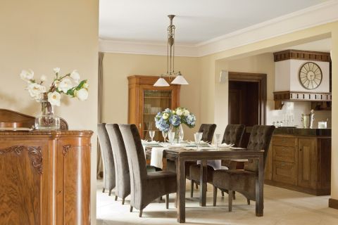 Beże i brązy, solidne dębowe meble i obraz z zabytkowym sportowym samochodem. Klasyka w najlepszym stylu.