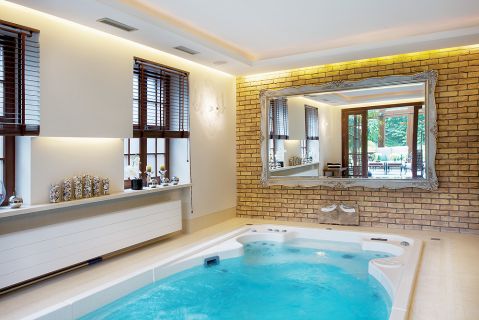 Ciekawy kontrast: ściany z cegły przeznaczonej na elewację i stylowa patynowana rama lustra.