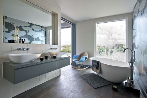 Dom nad jeziorem jest ogromny. Króluje w nim szarość, którą ogrzewają żółte dodatki i drewno z modrzewia syberyjskiego. Są