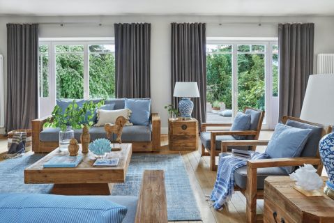 drewniane meble i niebieskie dodatki w salonie