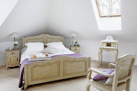 Fioletowe dodatki świetnie pasują do francuskiego stylu sypialni.