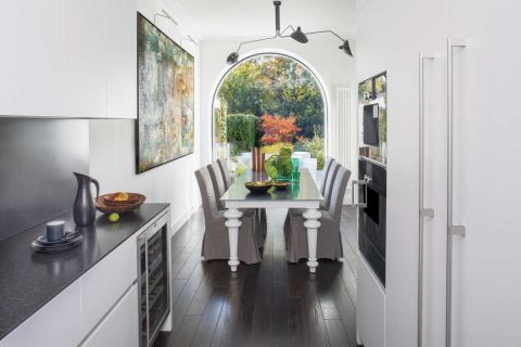 Stół z metalowym blatem – Gervasoni, lampa – Serge Mouille. Drzwi, okna i schody na wzór oryginalnych zrobiła polska