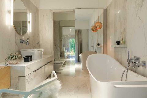 Lustro (drzwi do WC) odbija ścianę z oknem – łazienka wydaje się dwa razy większa. Ceramika Patricii Urquioli.