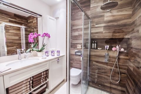 Połączenie imitacji drewna z przeszkleniami dodaje łazience nowoczesnego charakteru.