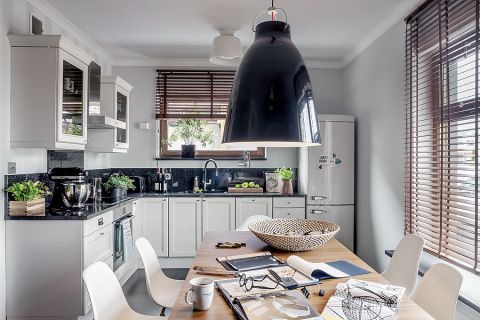 Rozsuwany jednym palcem stół marki Calligaris oraz krzesła Eamesów.