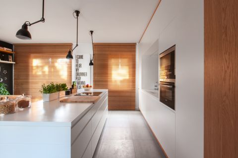 W oknach drewniane żaluzjo-rolety. Ciepłe drewno i chłodne szarości