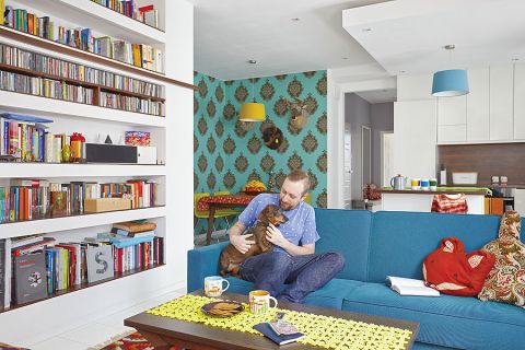 W salonie dwie kolorowe kanapy, vis-a-vis: niebieska i pomarańczowa.