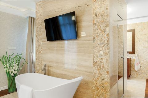 W sypialni stoi wanna, a nad nią wisi telewizor.