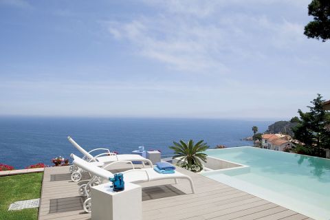 Wielki taras z leżakami i basenem. Willa w stylu marynistycznym