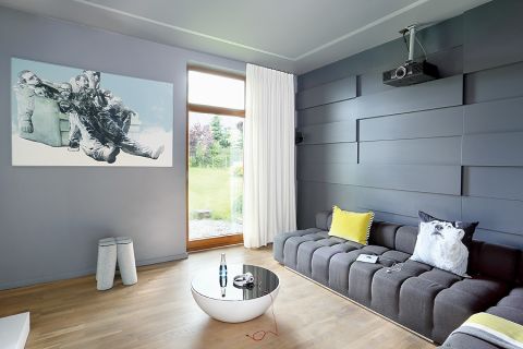 Wśród ciemnych ścian lepiej ogląda sie filmy. Dominującą czerń przełamuje filcowy stołek oraz żółta poducha