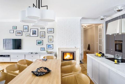 Część kuchenną od salonowej dzieli wygodny stół, przy którym można lepić pierogi albo je smakować, patrząc w ciepły ogień.