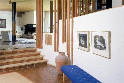 Kontrastowe zestawienia, np. szklane tafle obok prymitywnego kamiennego kominka,