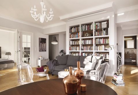 W suficie nad biblioteką schowany jest wysuwany ekran. Wystarczy nacisnąć pilota, zgasić światło, a salon zamieni się w małą