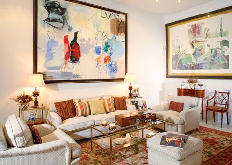 W salonie jasna kanapa i fotele oraz szklany stolik.