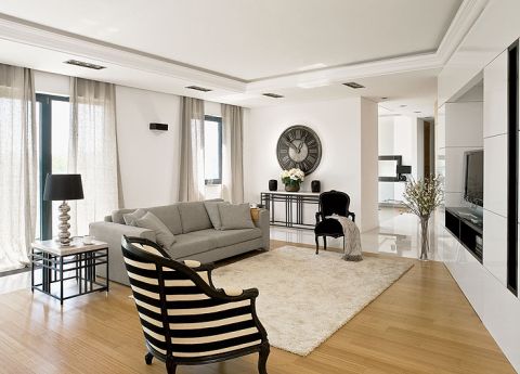 Pani domu powiesiła lniane zasłony, wstawiła kanapy i położyła dywan w ekologicznych kolorach.