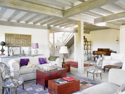 Czerwone elementy dominują na tle jasnych ścian i kanap.