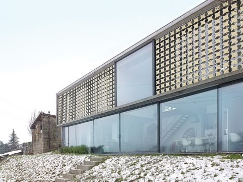 Za przytulny nastrój w sypialni odpowiadają ażurowe zewnętrzne żaluzje. Po pierwsze, pięknie wpuszczają światło, bo