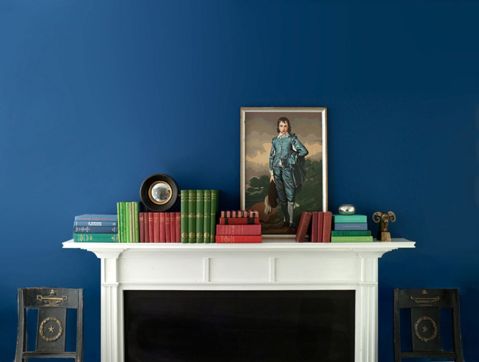 granatowa ściana z obrazami w salonie