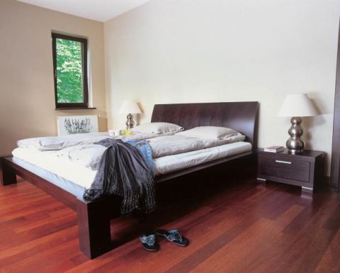 W sypialni łóżko z ciemnego drewna. Włoskie marzenie