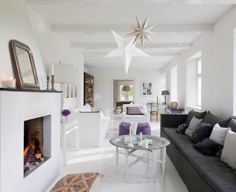 Tina kocha antyki i rękodzieło. Do białych ścian i podłóg odważnie dodaje ciemne poduchy, stare meble i chodniki.