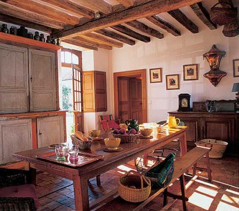 W kuchni stoi duży drewniany stół i ława.
