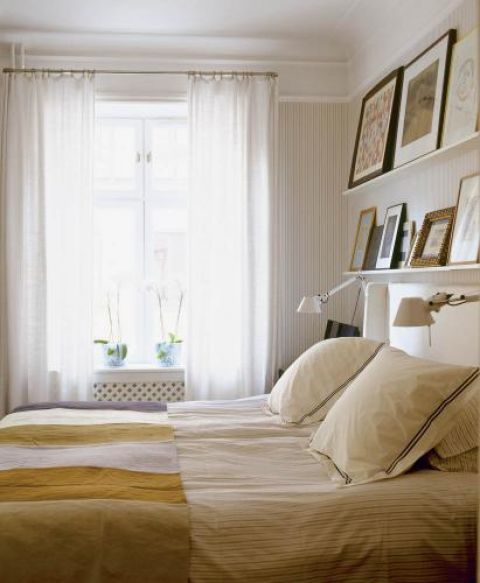 Jasną klasyczną sypialnię zdobią zdjęcia i obrazy.