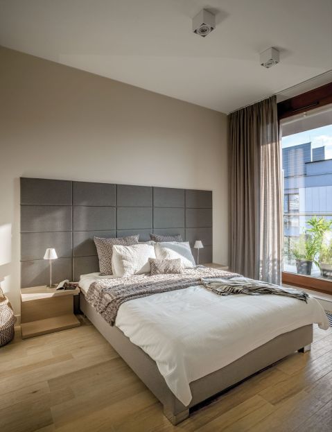 Zagłówkiem łoża w stylu hotelowym (na tapicerowanej ramie) są antracytowe panele przyklejane do specjalnego stelażu.