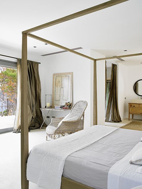 Mniej znaczy więcej. Proste łóżko z baldachimem, wiklinowe fotele i obrazy oparte o ścianę. I tak widoki są tu najważniejsze.