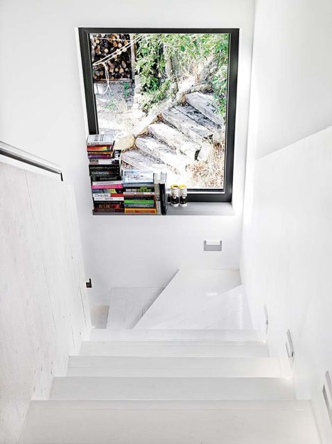 Światło wpadające przez wielkie odbija się od białych ścian, dodatkowo doświetlając dom.