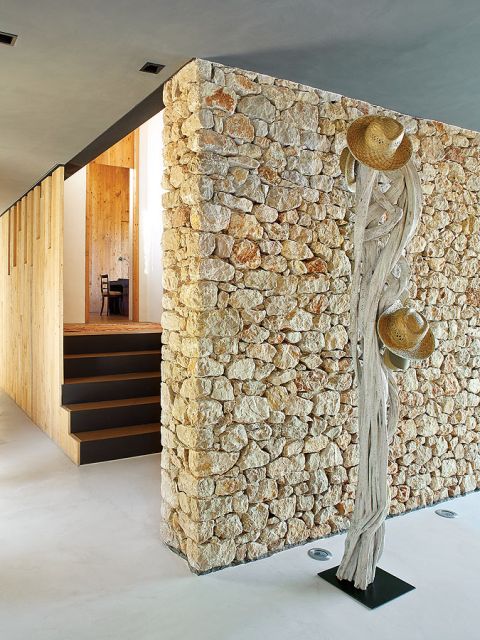 Kamień i drewno, oryginane detale, np. wieszak na kapelusze z pokręconych konarów, które wyrzuciło morze