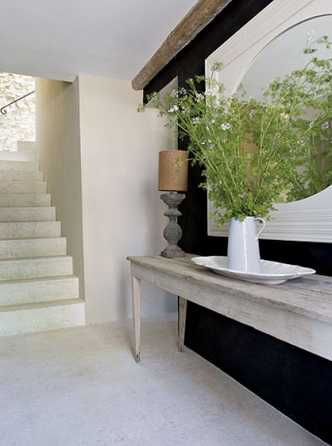 Gospodyni lubi kontrasty. Zgrzebną konsolę ustawiła na tle modnej, czarnej ściany.