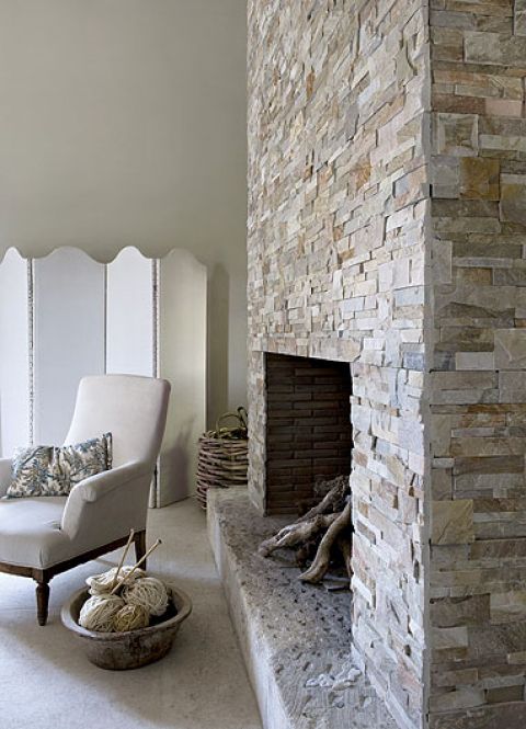 Naturalne matreiały, np. kamień na kominku, współgrają z naturalnymi tkaninami - lnem i płótnem.