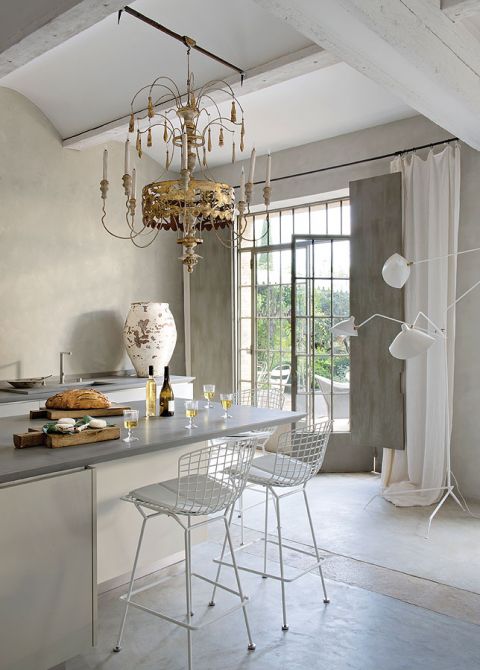 Minimalistyczne lampy francuskiego dizajnera Serge’a Mouille’a rozmieszczone są w kilku miejscach domu - m.in. w kuchni.