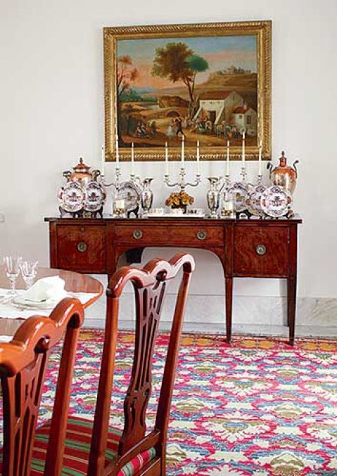 Dekoracja jadalni - na konsoli stoją ozdobne naczynia i świeczniki.