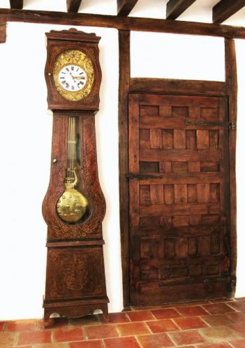 Stary, drewniany zegar z ornamentami.
