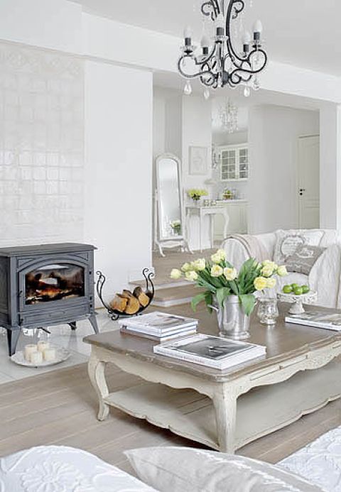 Wolnostojący kominek pasuje do białego wnętrza.