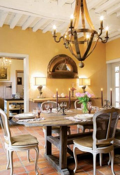 Prosty drewniany stół i zdobione krzesła.