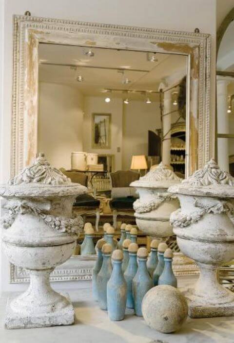 Przy lustrze stoją Kamienne dekoracje i ozdobne flakony.