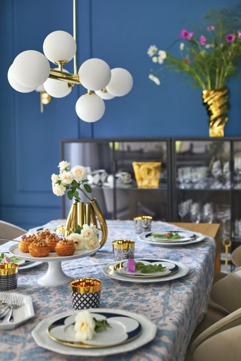 niebieska ściana w jadalni i złote dodatki