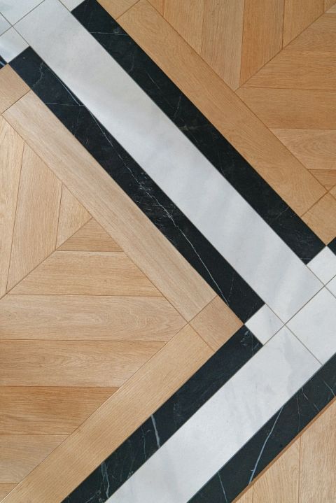 drewniany parkiet połączony z czarno-białymi płytkami ceramicznymi