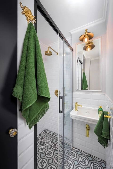 mała biała łazienka z czarnymi i złotymi dodatkami