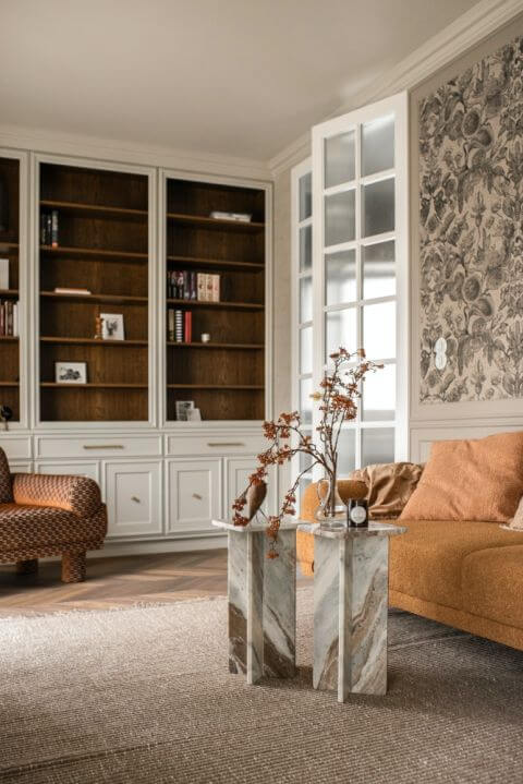 elegancki salon w stylu angielskim z biblioteczką i stolikami kawowymi z kamienia