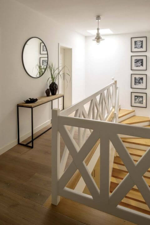 nowoczesny przedpokój ze schodami z białą balustradą o geometrycznym wzorze