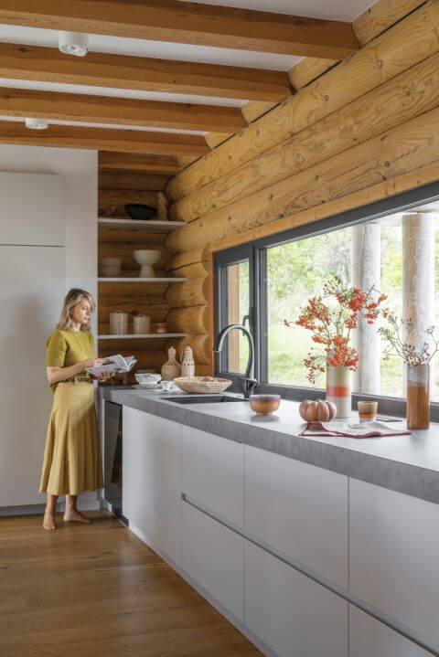 biała kuchnia z drewnem w domu z bali