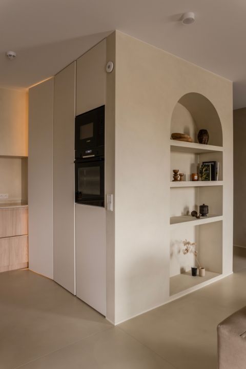 wnęka w kształcie łuku z półkami na książki i dekoracyjne przedmioty